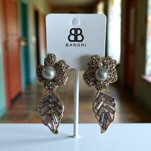 Bansri-flower-shaped stud encrusted with rhinestones and centered on faux pearl